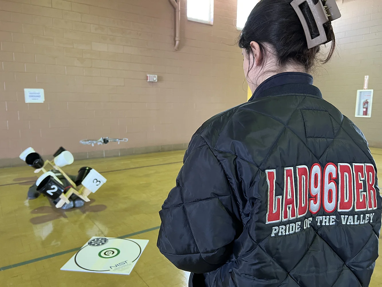 Fire department member flying a drone through a bucket-target training exercise